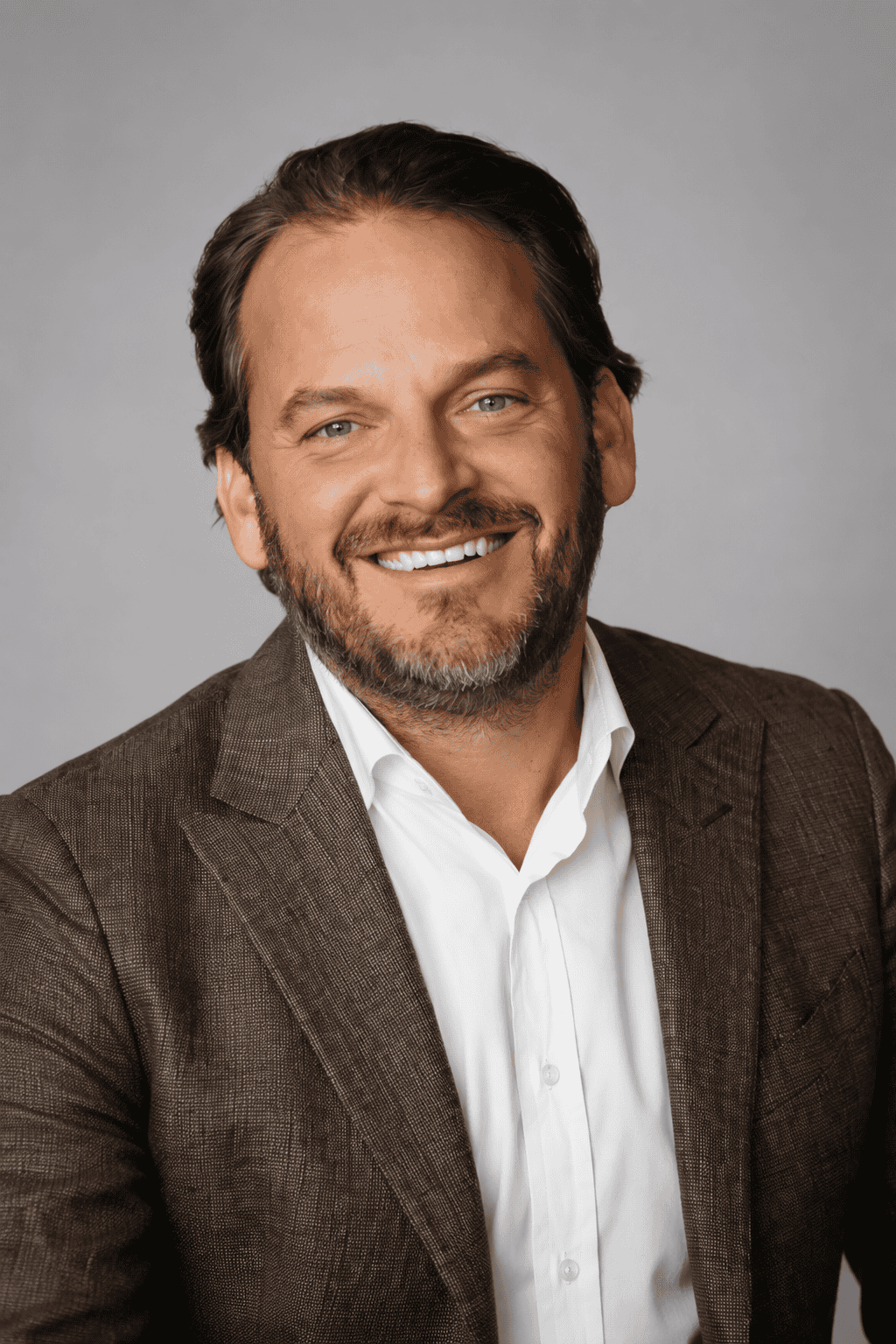 Professional portrait of Jon Chamlin in a brown blazer and white shirt.