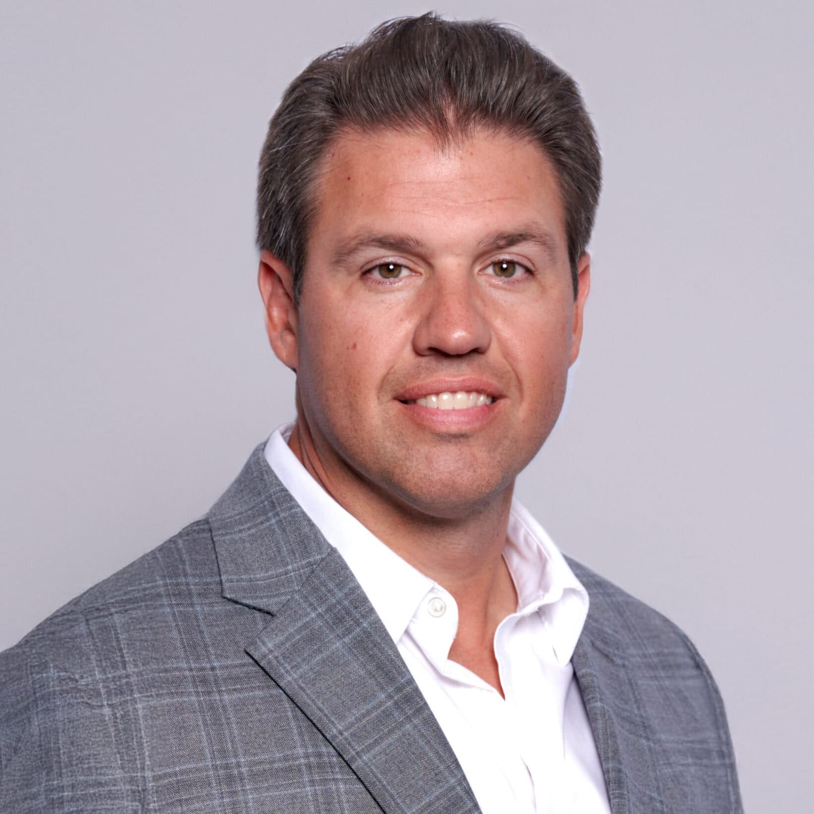 Professional portrait of a man in a gray suit and white shirt.