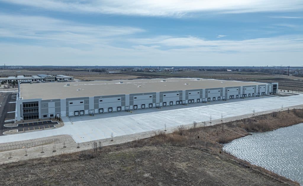 Large industrial warehouse building with multiple loading docks and parking area.